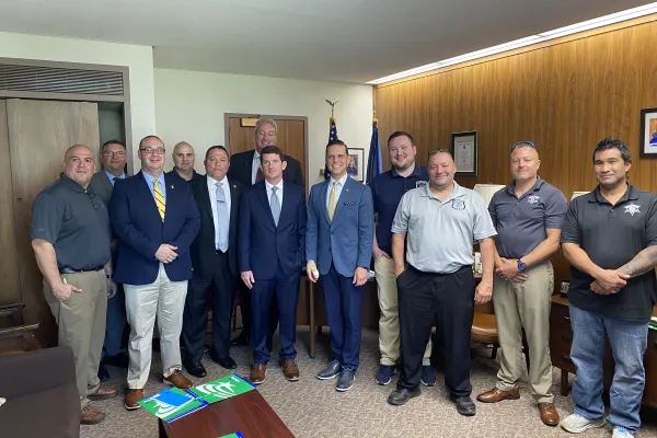 Members of Council 82 with New York state Assemblyman Angelo Santabarbara (center, yellow tie, in front of the flag). Photo credit: Aaron Gallant/AFSCME.