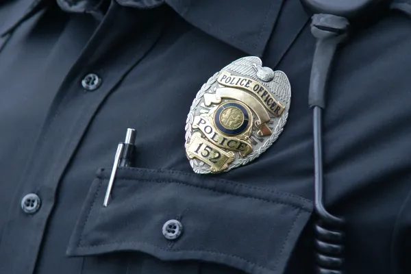 Stock image of a police officer wearing a badge.