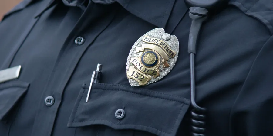 Stock image of a police officer wearing a badge.