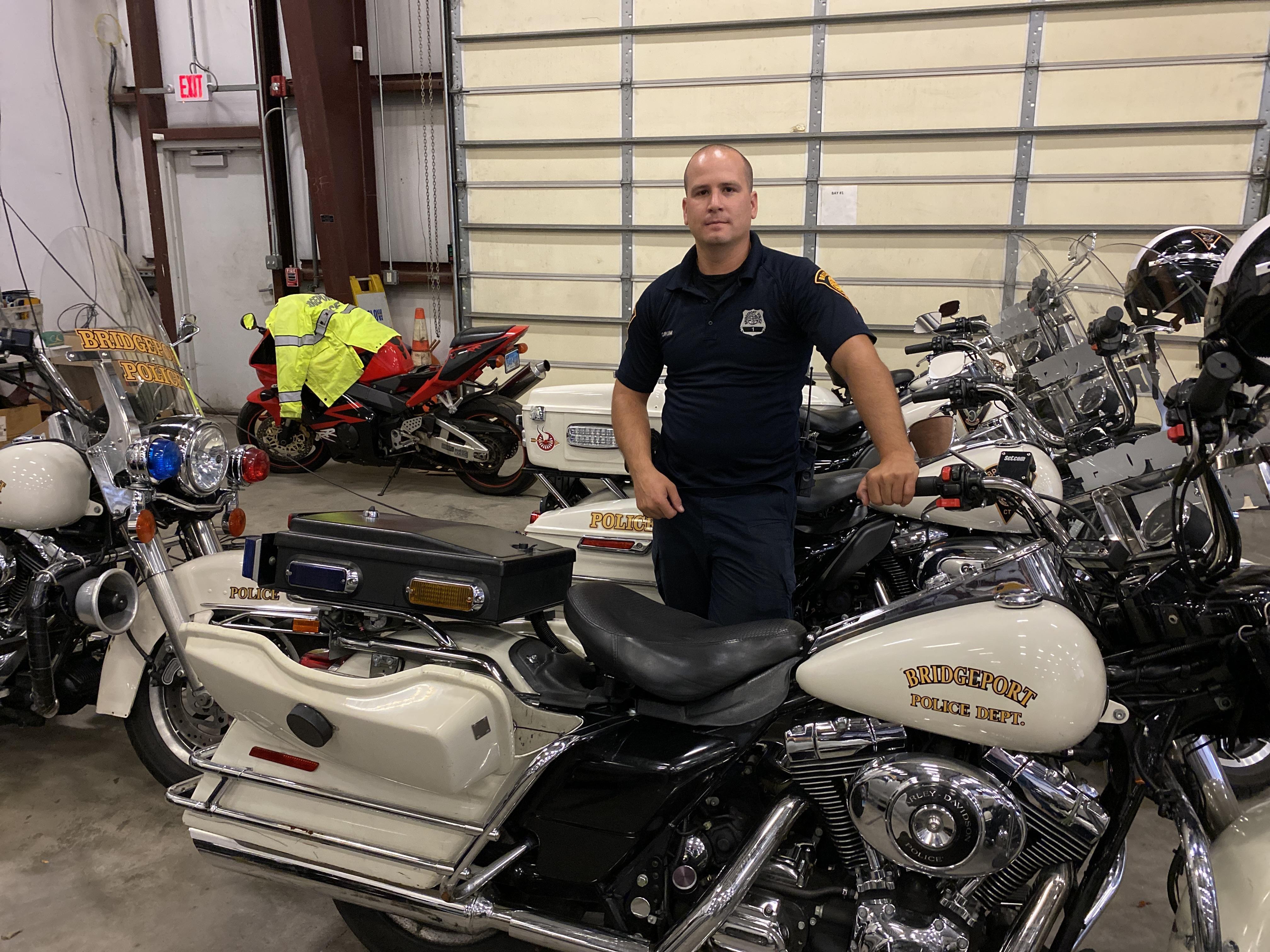 Orum standing next to a motorcycle at the Bridgeport Police Department Traffic Division garage. Photo credit: Aaron Gallant/AFSCME.